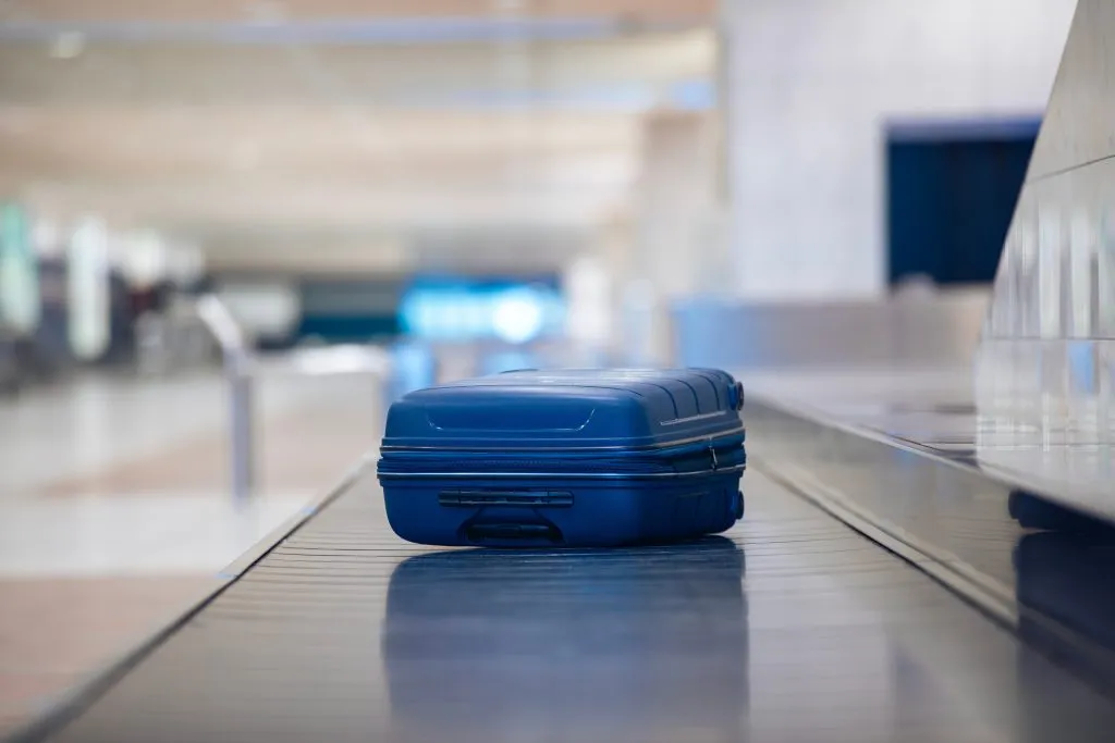 Traveling,By,Airplane.,Selective,Focus,On,Lonely,Blue,Suitcase,On